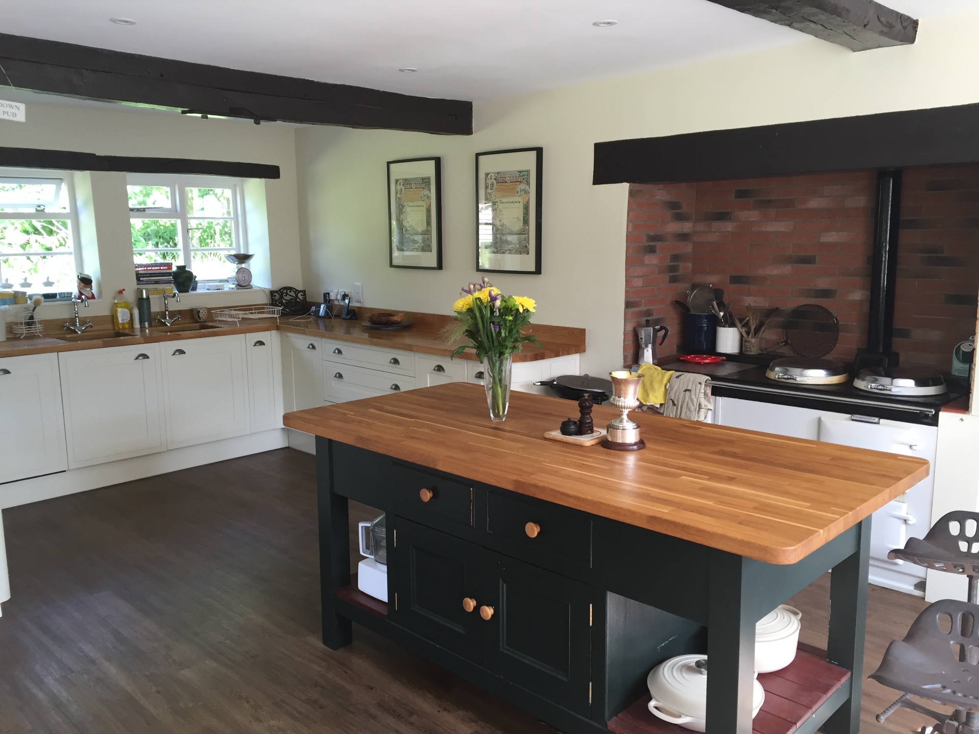 The farmhouse kitchen — oak worktops, butcher's block island and Aga beyond